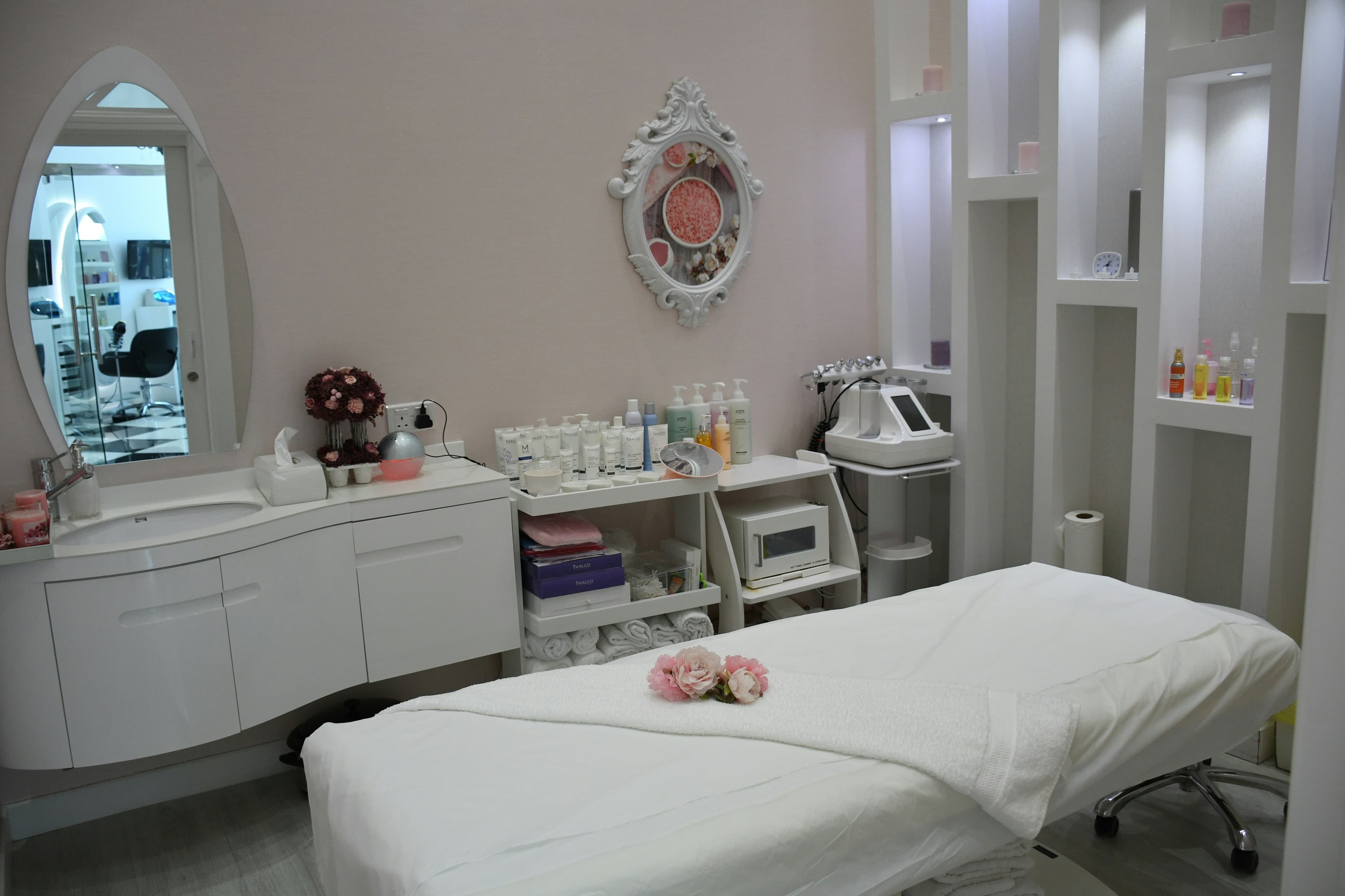 A white vanity table with a mirror, softly lit